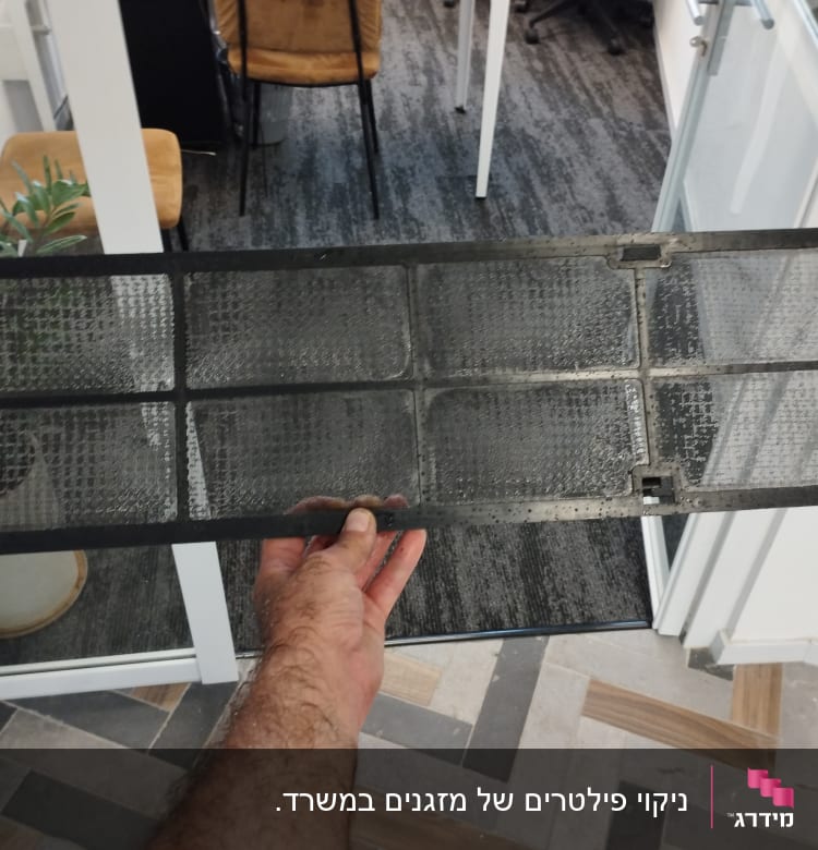 פילטר מזגן מוחזק ביד בתוך משרד
